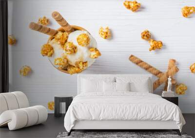 Ice cream with caramel and popcorn on a white table. Wall mural