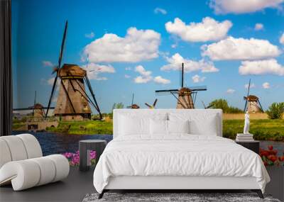 Colorful spring landscape in Netherlands, Europe. Famous windmills in Kinderdijk village with a tulips flowers flowerbed in Holland. Famous tourist attraction in Holland Wall mural