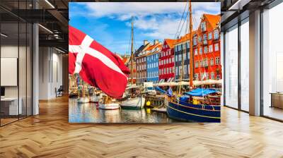 Copenhagen iconic view. Famous old Nyhavn port in the center of Copenhagen, Denmark during summer sunny day with Denmark flag on the foreground. Wall mural