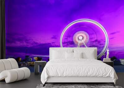 Spinning ferris wheel at sunrise blue hour in Rimini, Italy. Long exposure abstract image Wall mural