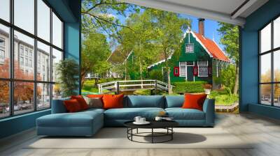 traditional green dutch house with little wooden bridge against blue sky in the zaanse schans villag Wall mural