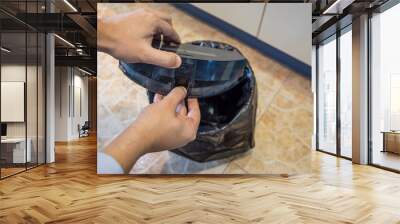 Emptying the dustbin of a robot vacuum cleaner Wall mural