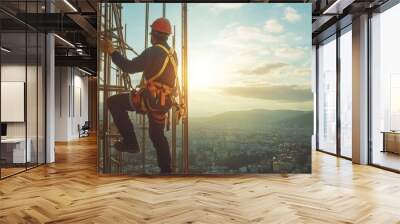 A construction worker scaling a high-rise scaffold against a vibrant sunset over a cityscape Wall mural