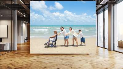 Disabled woman asia in a wheelchair with his family on the beach. Wheelchair woman sitting relax on the beach.  family relax concept Wall mural