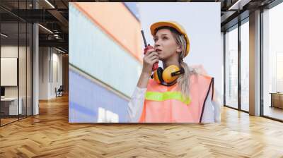 Female worker using handheld radio receiver for communication Wall mural