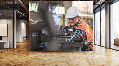 worker is working on a lathe machine in a factory. Turner worker manages the metalworking process of mechanical cutting on a lathe Wall mural