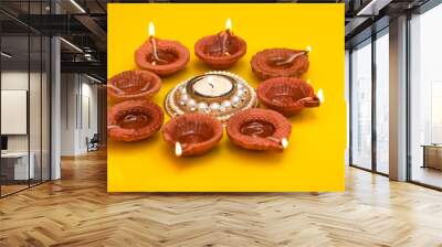 Concept of indian festival diwali. Traditional oil lamps on yellow background. Wall mural