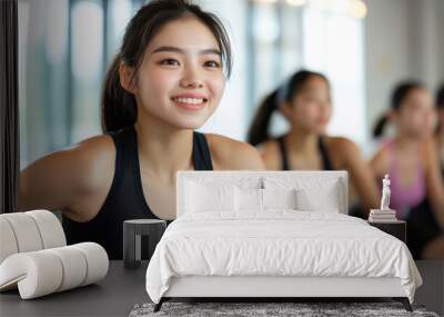 Group of active asian sports girls in black sportswear are engaged in budgie fitness in the gym Wall mural