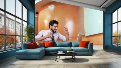 happy Indian businessman looks at the laptop screen and celebrating for good deal. Wall mural