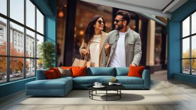 Happy indian couple enjoying shopping together. Wall mural