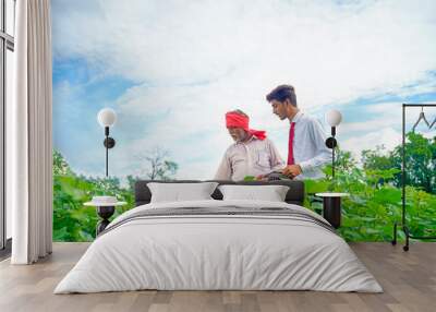 Indian farmer with agronomist at Cotton field , showing some information on tab Wall mural