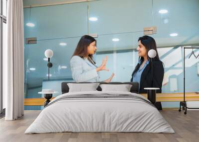 Two indian Corporate woman talking each other some subject at office Wall mural