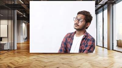 Young handsome indian college student giving thinking expression on white background Wall mural