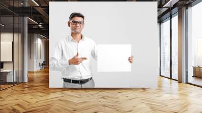 Young Indian business executive showing blank sign board over white background Wall mural