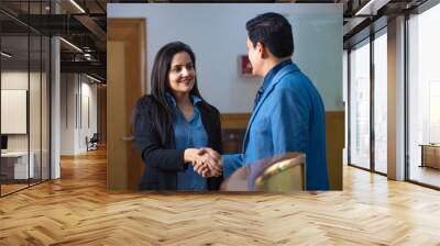 Young indian businesswoman shake hand with businessman at office. Wall mural