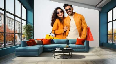 Young Indian couple holding shopping bags and expressing happiness Wall mural