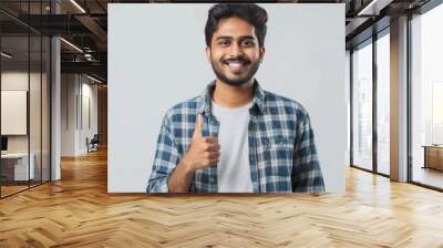 young indian man giving thumbs up on white background Wall mural