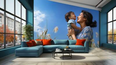 young indian mother with little baby having fun at field Wall mural