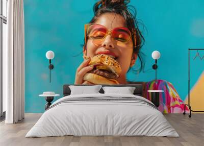 Young indian woman eating burger Wall mural