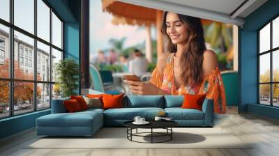 young indian woman sitting at cafe and using smartphone Wall mural