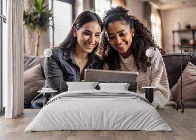 Two Friends Laughing While Using a Tablet on the Couch Wall mural