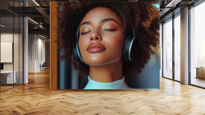 A woman enjoys a tranquil moment with headphones, eyes closed, her serene expression accentuated by soft lighting and a peaceful ambiance. Wall mural