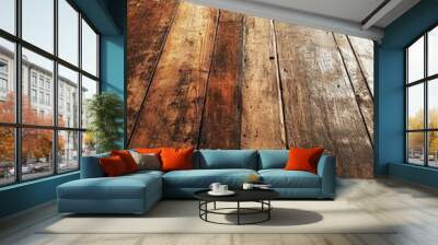 A close-up of weathered wooden floorboards with a warm, natural light illuminating the surface, creating a rustic and inviting atmosphere. The texture and grain of the wood are prominent, evoking a se Wall mural