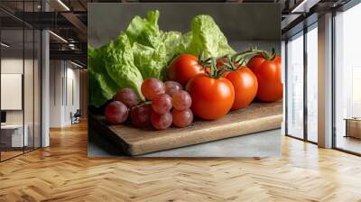 A close-up shot of fresh, vibrant seasonal produce on a wooden cutting board. The produce includes juicy red tomatoes, green lettuce, and purple grapes, symbolizing health, abundance, and the bounty o Wall mural