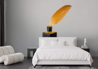 A golden quill pen rests in a glass inkwell filled with black ink, symbolizing creativity, artistry, literature, and the timeless power of the written word. Wall mural