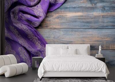 A purple patterned tablecloth with intricate designs lays on a rustic wooden surface, creating a beautiful and inviting backdrop for any occasion. The tablecloth's vibrant color and texture contrast b Wall mural