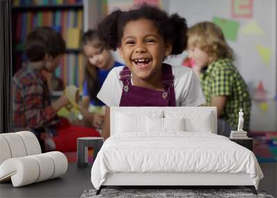 Close up portrait of smiling little African-American girl looking at camera at primary school Wall mural