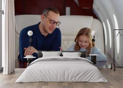 Father and daughter drawing with colorful pencils flying together on private jet Wall mural