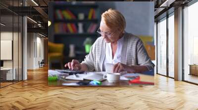 Senior business woman holding paper bill using calculator Wall mural