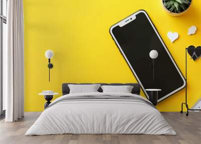 a cellphone and a cactus on a yellow surface Wall mural