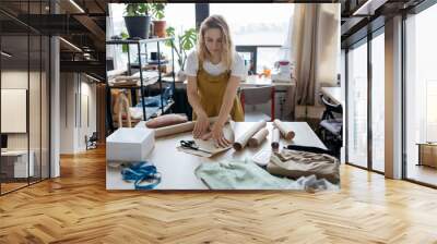 Female tailor working with paper patterns. Small business and self-employed women concept. Wall mural