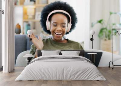 African woman using laptop and headphones while waving hello during a video call with friends. Student talking to her teacher and learning new language online during online course or private lesson Wall mural