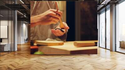 Hands, food and chef cooking sushi in restaurant for traditional Japanese cuisine or dish closeup. Kitchen, table for seafood preparation and person working with gourmet meal recipe ingredients Wall mural