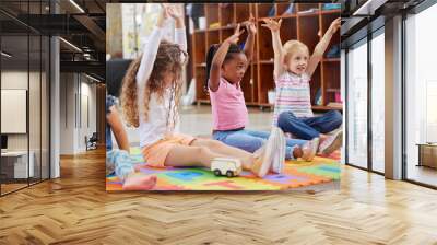 Interacting with other children is essential for social development. Shot of a group of children sitting in class. Wall mural