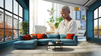 Making sure her tasks are done. Shot of a young businesswoman working on her laptop at her desk. Wall mural