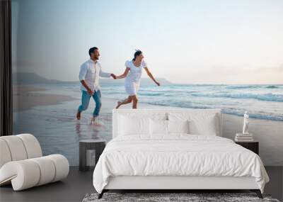 Nothing will stop us from being together. Shot of a young couple running on the beach. Wall mural