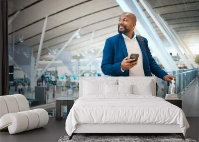 Black man waiting in airport with phone, smile and luggage in terminal for business trip. Technology, travel and happy businessman with international destination checking flight schedule app online. Wall mural