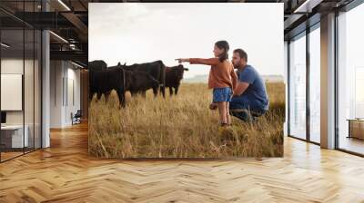 Family, dairy farming and farmer with child, daughter and girl pointing, showing and watching cows or cattle. Father and curious kid bonding on farm estate with meat, beef and food industry livestock Wall mural