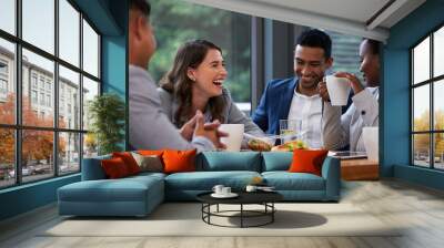 If you can laugh together, you can work together. Shot of a group of colleagues having a meeting and breakfast in a modern office. Wall mural