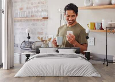 Phone, coffee and social media with a man in the kitchen of his home in the morning with a smile. Mobile, communication and internet with a young male reading a text message in his house alone Wall mural