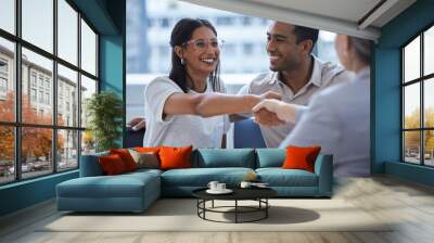 She is the best day of my life. Shot of a young couple sharing a handshake with a consultant theyre meeting to discuss paperwork an office. Wall mural