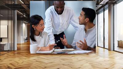 Success on infinite repeat. Shot of diverse group of businesspeople having a quick meeting in an office. Wall mural