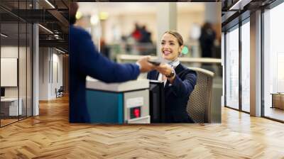 Woman, airport and service agent with passport helping traveler for check in at terminal counter. Female passenger assistant with smile in travel security or immigration documents for airline control Wall mural