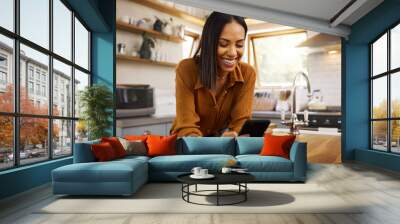 Happy woman, phone text and kitchen in a home reading a web app. House, female and smile of a young person with joy resting on a counter top table feeling relax typing with mobile networking Wall mural