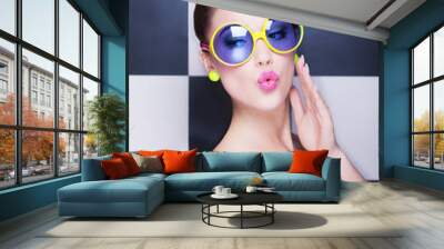 Attractive surprised young woman wearing sunglasses Wall mural