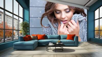 Beautiful natural young  brunette woman with eyes closed, wearing knitted scarf, covered with snow flakes. Snowing winter beauty concept. Wall mural